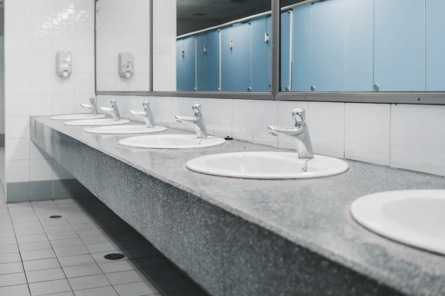 Wastafel dan urinoir di toilet umum yang bersih
