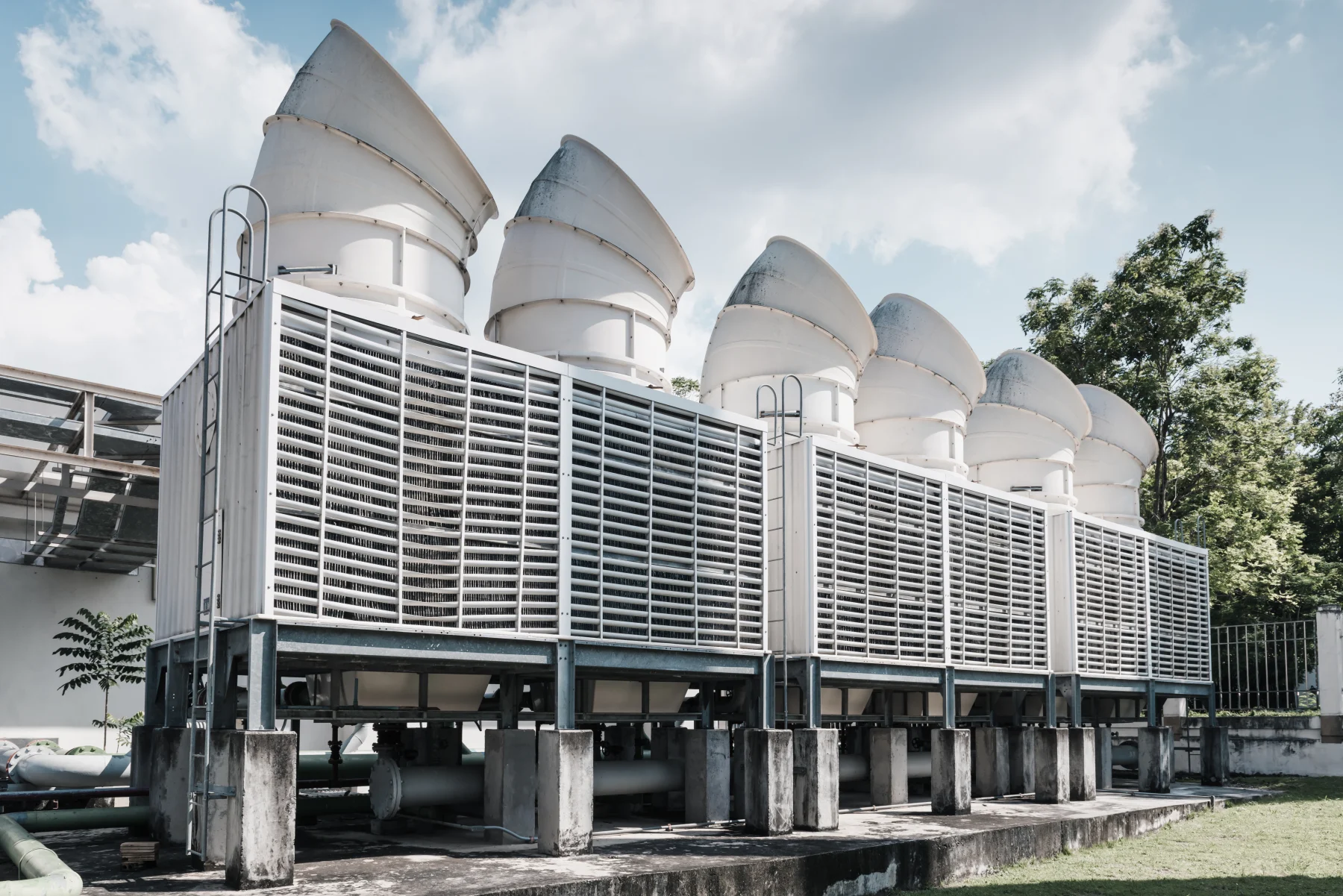 Deretan cooling tower di area pabrik dengan langit cerah