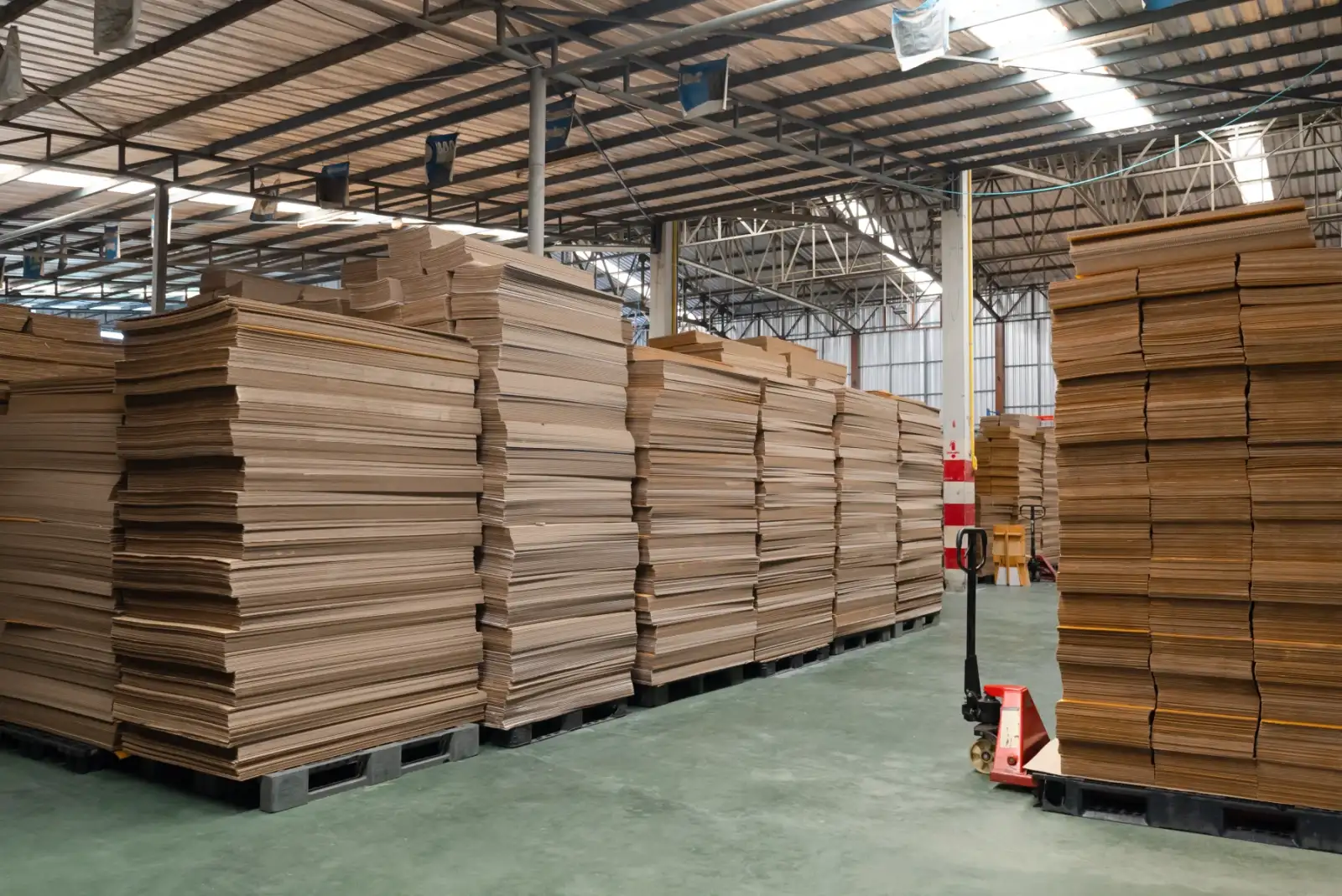 Tumpukan kertas corrugated siap kemas di pabrik