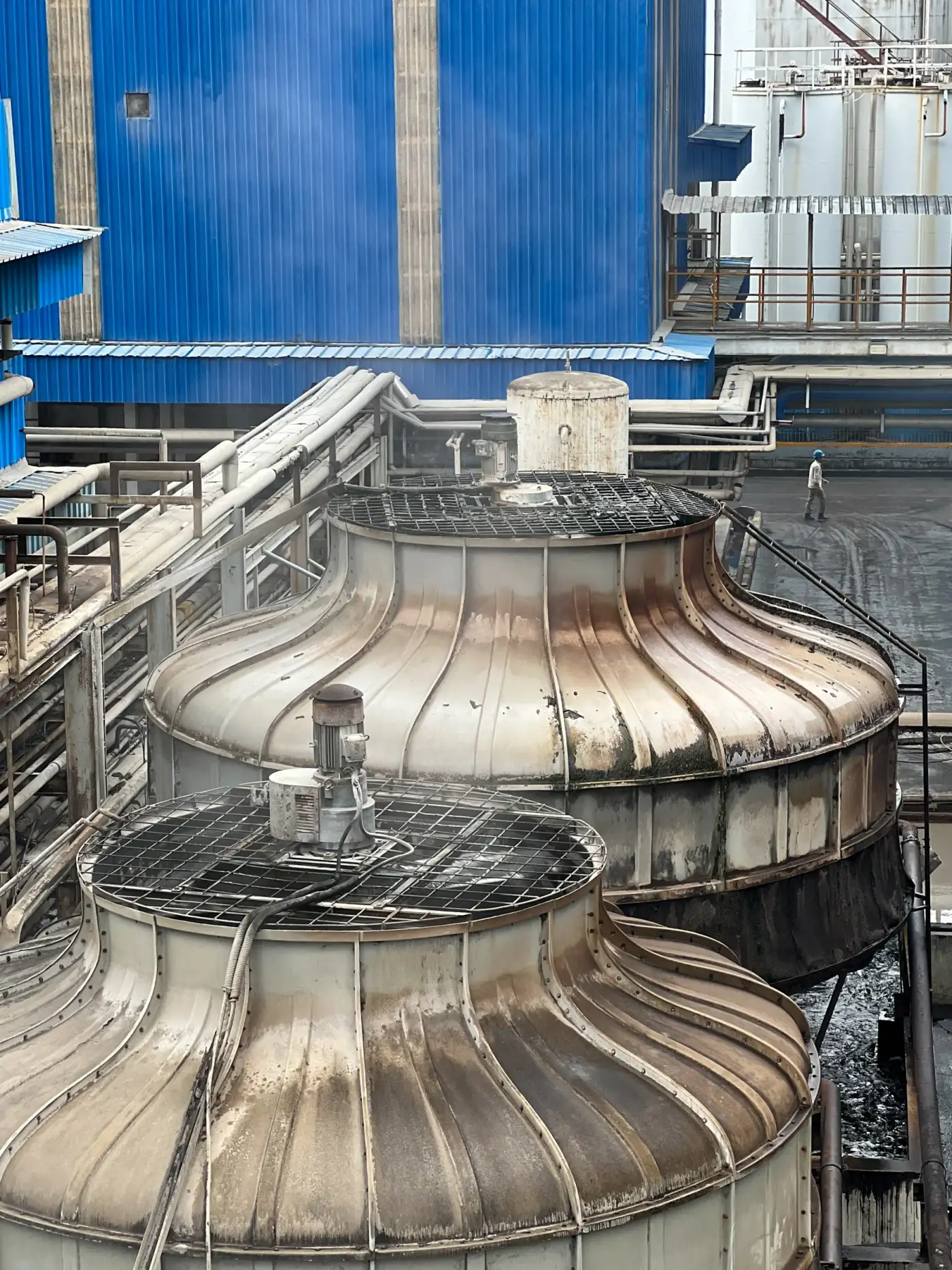 Deretan cooling tower besar dengan perpipaan