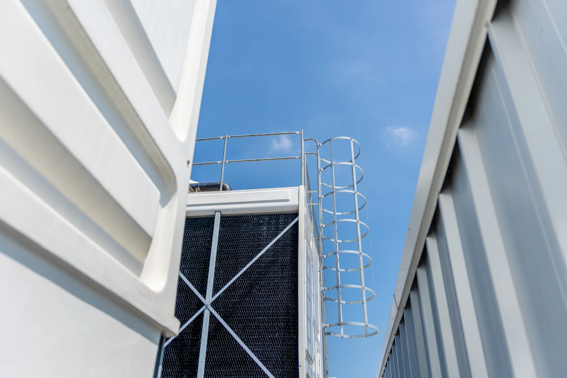 Peralatan cooling tower industri dengan tangga pengaman dan perpipaan